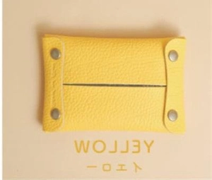 Detail of yellow lychee grain leather mini organizer pouch with metallic snap fasteners