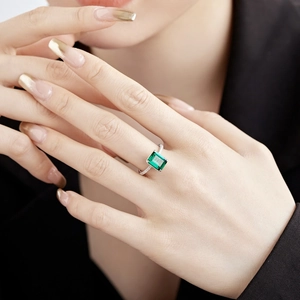 Macro shot of rectangular emerald-cut green stone with micro-pave zircon on silver band
