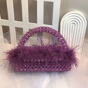 Close-up of purple beaded evening bag with fluffy ostrich feathers and intricate beadwork