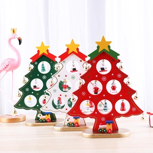 Three colorful wooden Christmas tree table ornaments with miniature dolls and gold bells