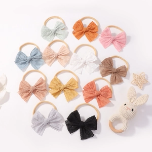 Set of 12 hollow lace bow headbands for babies with a cute knitted rabbit toy