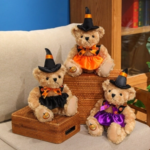 Three Halloween witch teddy bears in orange, black, and purple dresses sitting on a basket