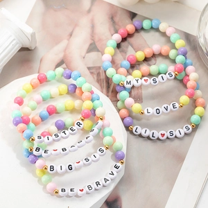 Detail of colorful acrylic beaded bracelets with Sister and Love letter charms for girls