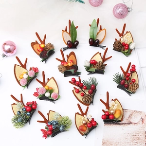 Detailed view of Christmas hair clips with reindeer antlers, pine cones and red berries