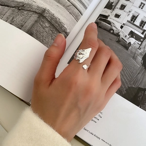 Detailed view of S925 sterling silver ring with irregular textured surface on model hand