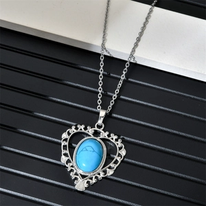 Vue macro d'un pendentif cœur évidé avec turquoise bleue sur une chaîne argent