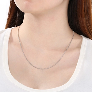 Détail d'un collier ras de cou minimaliste en acier inoxydable argenté sur un mannequin
