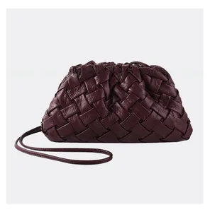 Detail of dark burgundy woven leather texture on a stylish croissant cloud crossbody bag