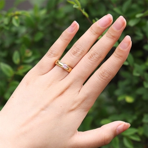 Detail of 18k gold plated ring with a pink rectangular zircon stone on a model's hand