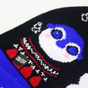 Detail view of knitted Christmas hat showing cartoon penguin and LED ON/OFF power switch