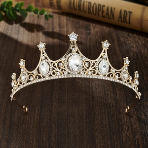 Detail of vintage gold crown for girls with clear rhinestones on dark wood background