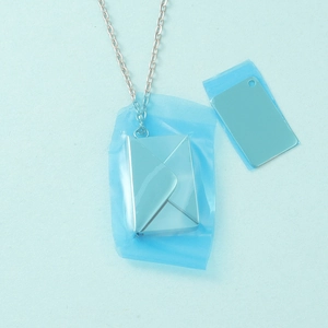 Macro shot of silver envelope locket with removable card and blue protective film