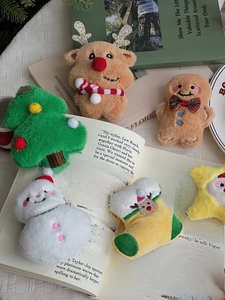 Close-up of plush Christmas ornaments including reindeer and snowman on an open book