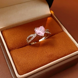 Close-up of pink heart-shaped gemstone ring with micro-pave diamonds in an orange box