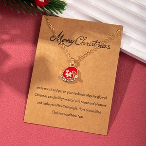 Detailed view of Christmas hat pendant on gold chain with Merry Christmas gift card