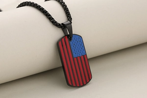 Close-up of military dog tag pendant with American flag enamel pattern on black necklace