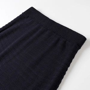Detailed macro shot of deep blue knitted skirt with herringbone texture and ribbed waist