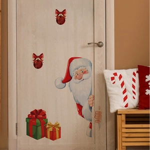 Détail de stickers Père Noël et cadeaux sur une porte en bois pour l'ambiance de Noël