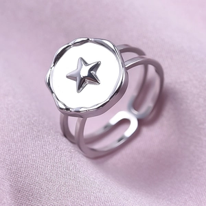 Macro detail of silver stainless steel ring with star emblem and double layer open band
