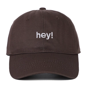 Gros plan détaillé de la broderie blanche hey sur le tissu marron foncé de la casquette