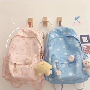 Detail of pink and blue bear print backpacks featuring cute plush bear charms and star pendants