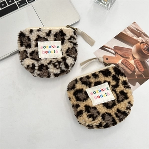 Detail shot of leopard print plush coin purses with zipper and woven label decoration