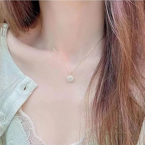 Elegant gold spinning sunflower necklace with sparkling diamonds on a female model