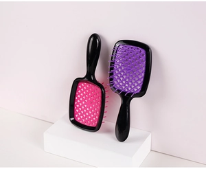 Detail of pink and purple hollow mesh hair brushes for detangling and scalp massage