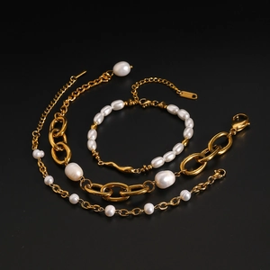 Detail view of gold stainless steel link chains and white freshwater pearls set on black