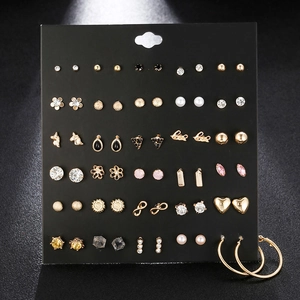 Detailed close-up of 30 pairs of rhinestone and pearl alloy stud earrings on a display board