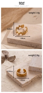 Detailed views of gold leaf and wheat grain textured open rings on natural stone