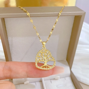 Close-up of golden heart pendant with tree of life design and sparkling zircons