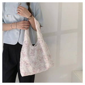 Close-up of pink butterfly embroidery on white textured fabric tote bag for women