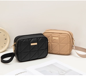 Detail of crossbody camera bags with quilted texture and gold rectangular plaques