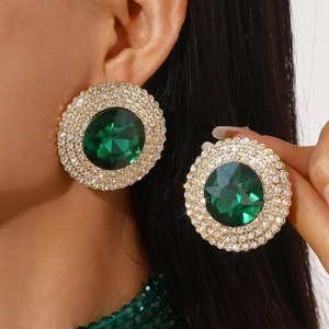 Detail of luxury round green gemstone earrings with sparkling crystal halo setting