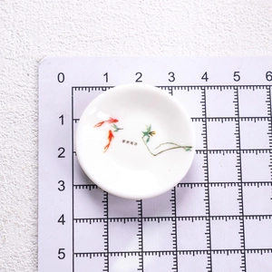 Miniature blue and white porcelain plate showing 3.8 cm diameter size on a ruler mat