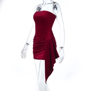 Dettaglio dell'abito in velluto bordeaux con texture ricca ed eleganti drappeggi laterali