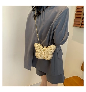 Sac papillon doré à strass avec bandoulière chaîne porté sur un blazer anthracite