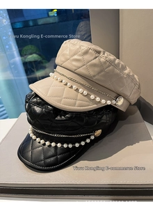 Close-up of quilted PU leather newsboy caps with elegant gold chain and pearl trim