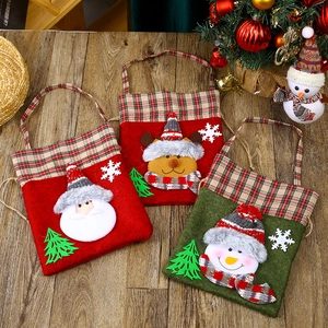 Detailed view of Christmas non-woven gift bags with reindeer and Santa plaid designs