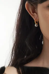Close-up of S925 silver gold-plated hoop earrings with carved patterns and grey pearls