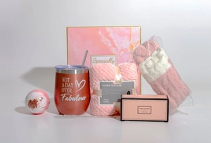 Detailed gift set featuring a rose gold tumbler and pink relaxation items in a box