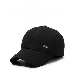 Detail of mountain-shaped metal logo on black winter wool baseball cap with thick texture