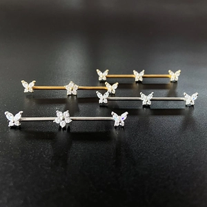 Set of stainless steel industrial barbell earrings with butterfly and flower crystal motifs