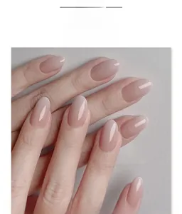 Detail of nude pink ombre oval press-on nails with a glossy polished finish