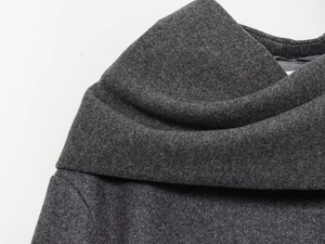 Detail of dark gray wool fabric texture and layered collar stitching on a navy coat
