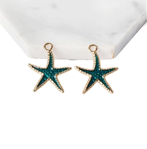 Detailed macro view of two gold starfish pendants with dark green enamel and small rings