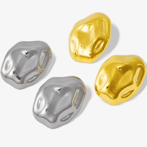 Macro detail of irregular lava-style stainless steel stud earrings in gold and silver finish