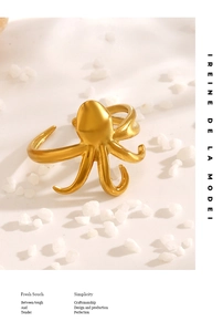 Detailed shot of golden octopus ring with satin finish on white minimalist background