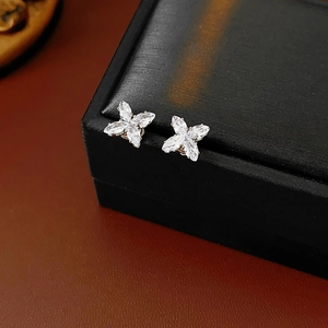Gros plan de boucles d'oreilles fleur à quatre pétales en argent avec des oxydes de zirconium